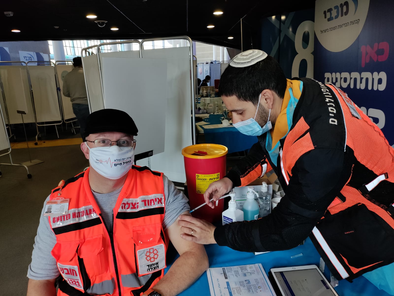 One United Hatzalah volunteer vaccinating another in Jerusalem in December