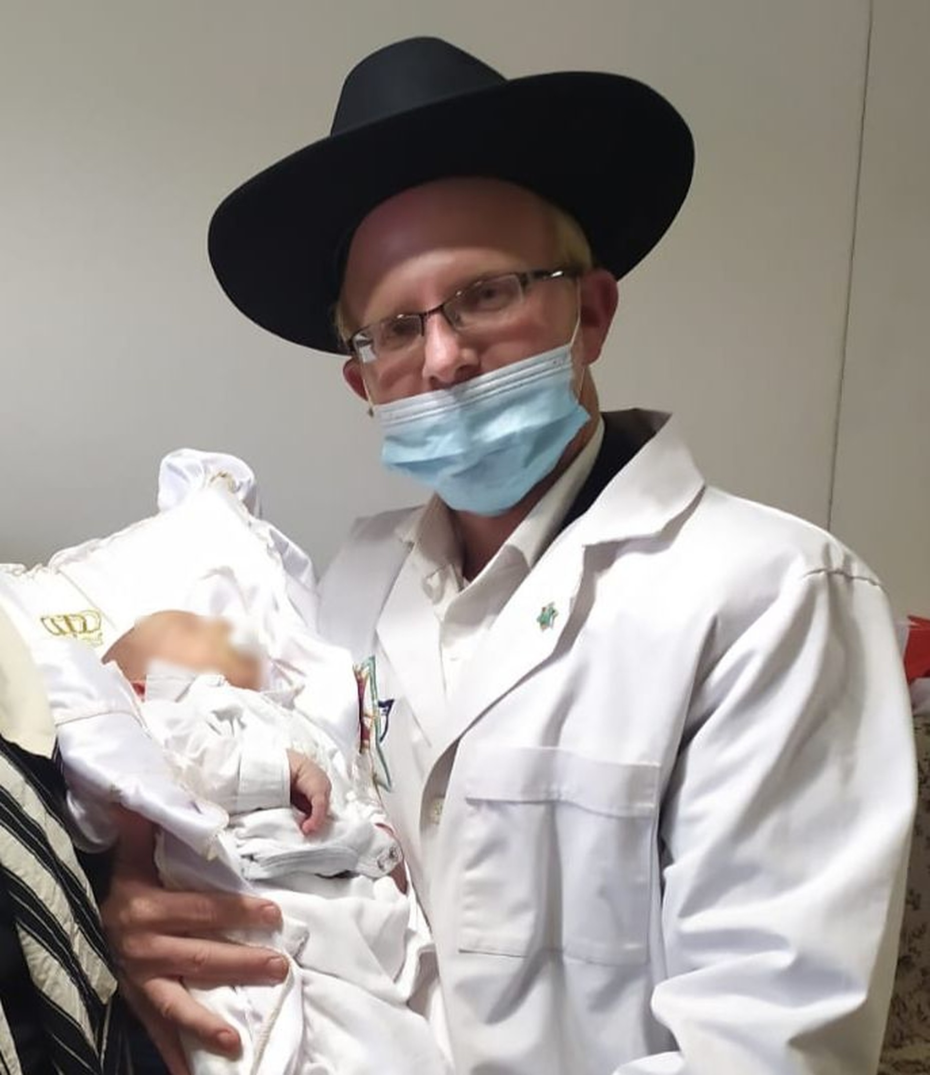Rabbi Nir Dorfman holding the baby after the Bris.v1 1