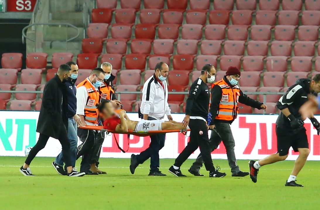 UH teams carryin an injured player off the fieldduring a soccer match censored