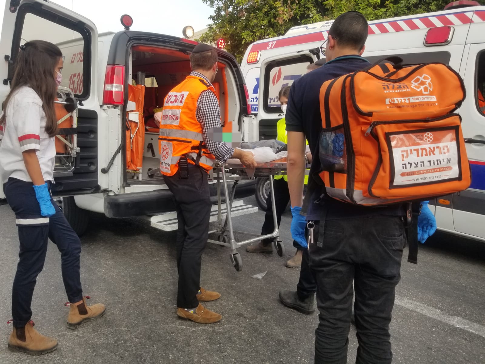 UH volunteers assist in putting patient onto an ambulance for transport