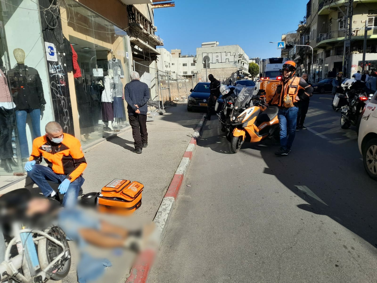 United Hatzalah first responders treating a collapsed person on the street Illustration 1