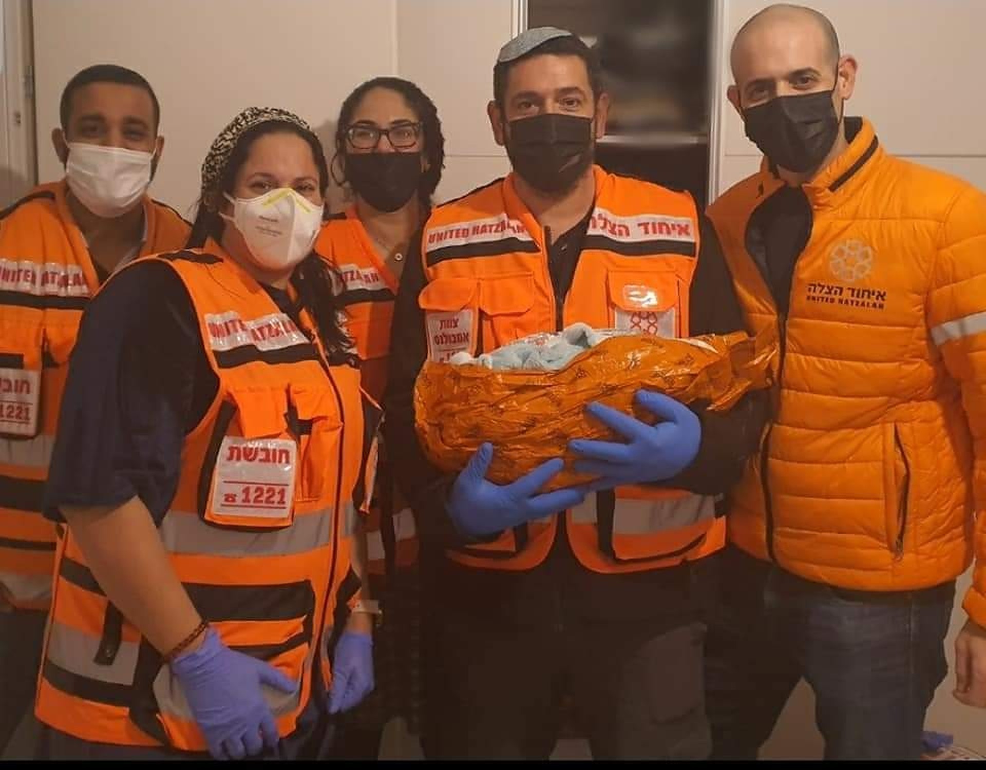 United Hatzalah volunteers pose with a newborn infant after an emergency home birth illustration.v1 2