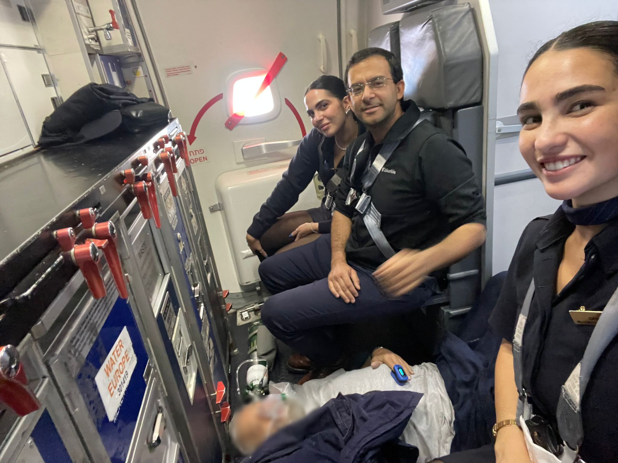 Dr. Ungar together with the flight crew watching over the revived patient